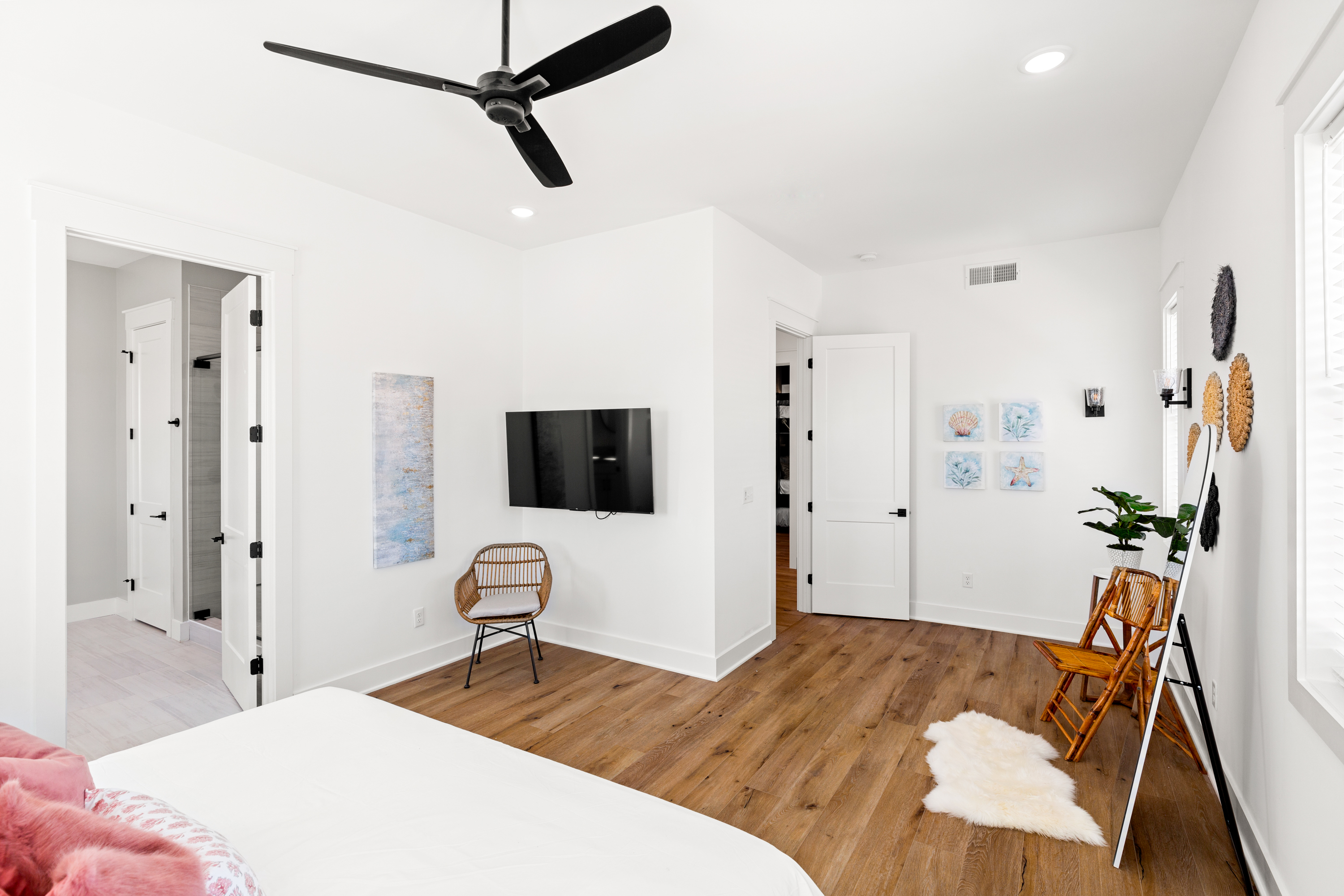 Large bedroom with wooden flooring and modern decor